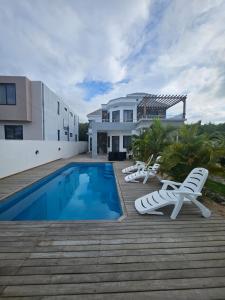 a house with a swimming pool and lounge chairs at Silverwood in Pereybere