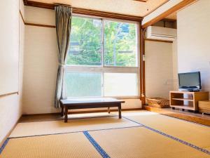 salon z dużym oknem i ławką w obiekcie Guesthouse KAZURABASHI w mieście Miyoshi