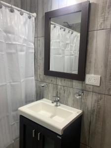 Un baño con un lavabo blanco y un espejo. en Bouchard-Ushuaia Flat, en Ushuaia 23 fotos más