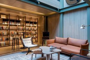 a living room with a couch and a book shelf at Atour Hotel Shanghai World Expo West Gaoke Road in Shanghai