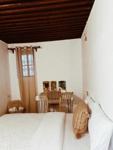 a bedroom with a white bed and a table at Tarbi'aat Tetaoun 44, 17th century heritage in Tetouan