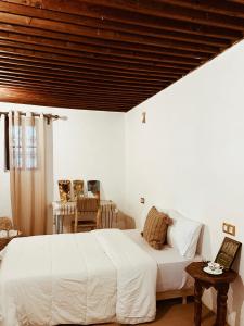 a bedroom with a white bed and a wooden ceiling at Tarbi'aat Tetaoun 44, 17th century heritage in Tetouan