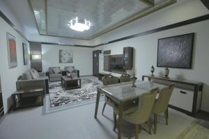 sala de estar con mesa de comedor y sofá en Niyaf Hotel Appartments, en Khamis Mushayt