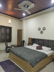 - une chambre avec un lit et un ventilateur de plafond dans l'établissement Varanasi homestay, à Varanasi