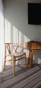 una silla de madera junto a una mesa y una TV en Rosevears Riverview Hotel en Rosevears
