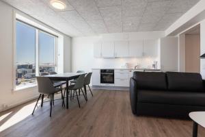 kuchnia i salon ze stołem i krzesłami w obiekcie Hotel Aurora Apartments w mieście Nuuk