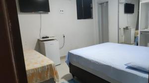 a small room with two beds and a television at Pousada ji Paraná in Ji-Paraná