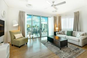 a living room with a couch and a table at Cairns City & Ocean View, 1 BR Sleeps 4 Spacious Apt in Cairns