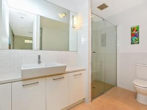 uma casa de banho branca com um lavatório e um chuveiro em Breeze Beachfront Apartment em Victor Harbor
