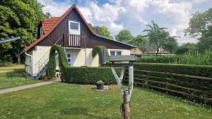 uma casa com um telhado coberto de hera e uma casa em Ferienhaus Kleinmoellerchen em Neu Poserin