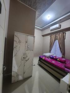 HomeStay Pandan Baru في Halangan: غرفة فيها سرير وثلاجة
