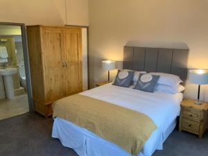 1 dormitorio con 1 cama grande y baño en The Sun Inn en Windermere