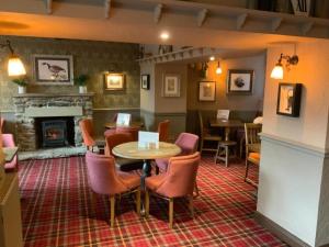 a restaurant with a table and chairs and a fireplace at The Sun Inn in Windermere