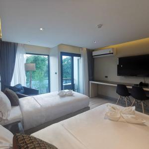 a hotel room with a large bed and a flat screen tv at The 9 Residence Hotel in Bangkok