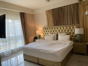 - une chambre avec un grand lit et une grande fenêtre dans l'établissement CHEZ SILVIA DUBAI MARINA &JBR Rimal, à Dubaï