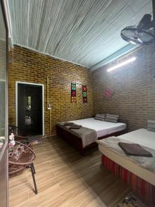枚州的住宿－Hakuna Matata Mai Châu，一间设有两张床和砖墙的房间