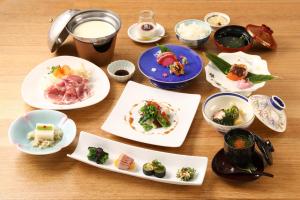 uma mesa de madeira com pratos de comida em Suzuranso em Komagane