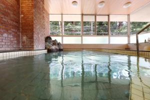 una piscina con agua en una habitación con ventanas en Suzuranso en Komagane