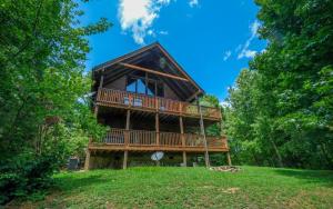 a tree house with a deck on a hill at Brink of Paradise in Gatlinburg
