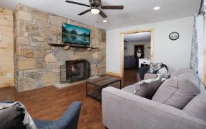 a living room with two couches and a stone fireplace at Big Oak Hideaway in Gatlinburg