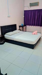 a bedroom with two beds and a purple window at Kuantan Town House in Kuantan