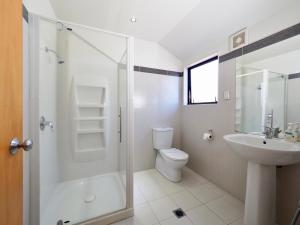 een badkamer met een douche, een toilet en een wastafel bij Ulster Lodge Motel in Hamilton
