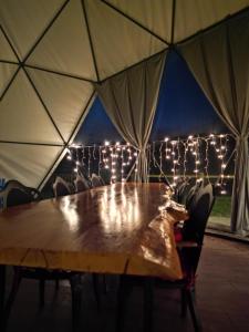 Kaynaşlı的住宿－Nandu Dogal Yasam Ciftligi，帐篷内的木桌和灯