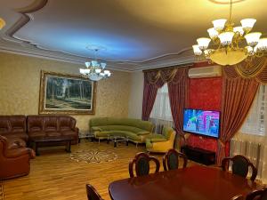 un soggiorno con divani, tavolo e TV di Luxury villa 8 bedrooms a Baku