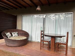 weranda z wiklinowym krzesłem, stołem i oknem w obiekcie Villas Pratagy Resort w mieście Maceió