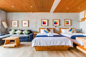 a bedroom with two beds and a couch at Harajuku lnn in Eluan