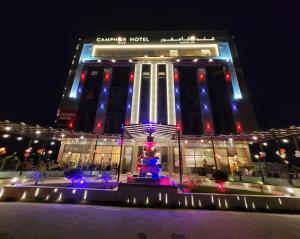 een gebouw met 's nachts een fontein ervoor bij Camphor Hotel in Ras al Khaimah