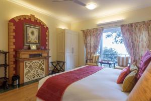 ein Schlafzimmer mit einem großen Bett und einem Fenster in der Unterkunft Raman Villa, Shimla, amã Stays & Trails in Shimla