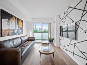a living room with a couch and a table at Sleek 1BR & office Condo - CN Tower, Skyline view in Toronto