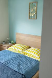 um quarto com uma cama azul e um edredão amarelo e azul em Apartament Kościuszki Chorzów em Chorzów