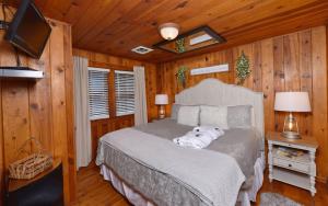 ein Schlafzimmer mit einem Bett in einem Zimmer mit Holzwänden in der Unterkunft River Romance in Gatlinburg