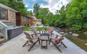 a patio with a table and chairs and a river at River Romance in Gatlinburg
