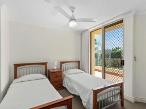 two beds in a room with a window at Casa del Rey 1 in Gold Coast