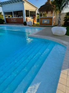 una piscina de agua azul frente a una casa en La Siègià Resort spa, en Massa Marittima