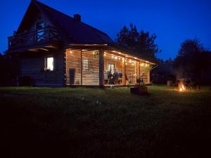 una cabaña de madera iluminada por la noche con luces en Sielankowe Pole, en Józefów