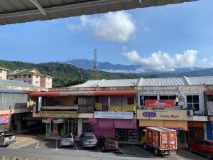 a group of buildings with cars parked in a parking lot at Suria Paradise Lodge in Ranau