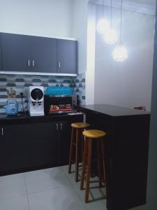 セパンにあるSP Sepang Homestay Klia/Klia2のキッチン(黒いカウンター、スツール2脚付)