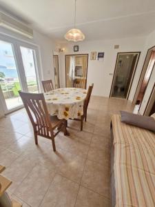 uma sala de jantar com mesa e cadeiras em Apartments Mira - 20 m from pebble beach em Zaboric
