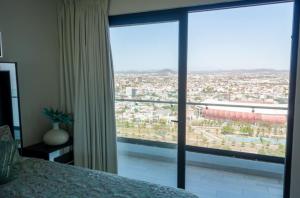 马萨特兰Altomare depa 2001的一间卧室设有一张床和一个大型玻璃窗