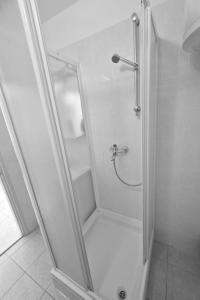 um chuveiro com uma porta de vidro na casa de banho em Apartments Mira - 20 m from pebble beach em Zaboric