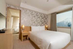 a bedroom with a large white bed and a window at Chalet Ivy Hirafu in Niseko