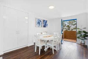 una sala da pranzo bianca con tavolo e sedie bianchi di Nautica Residences Hillarys a Perth