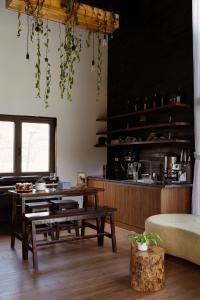 a living room with a table and a bench and a kitchen at Mật Pet Farm - Mộc Châu in Mộc Châu +25 photos