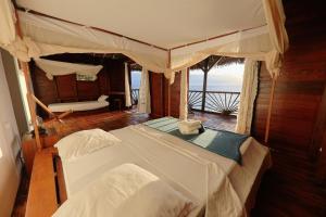 een slaapkamer met 2 bedden en uitzicht op de oceaan bij Nosy Komba Lodge in Nosy Komba