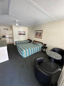 a hotel room with a bed and a table and chairs at Motel Bream in Mallacoota