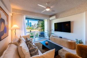 a living room with a couch and a tv at Skyline and Riverview 2 bedrooms apartment in Brisbane